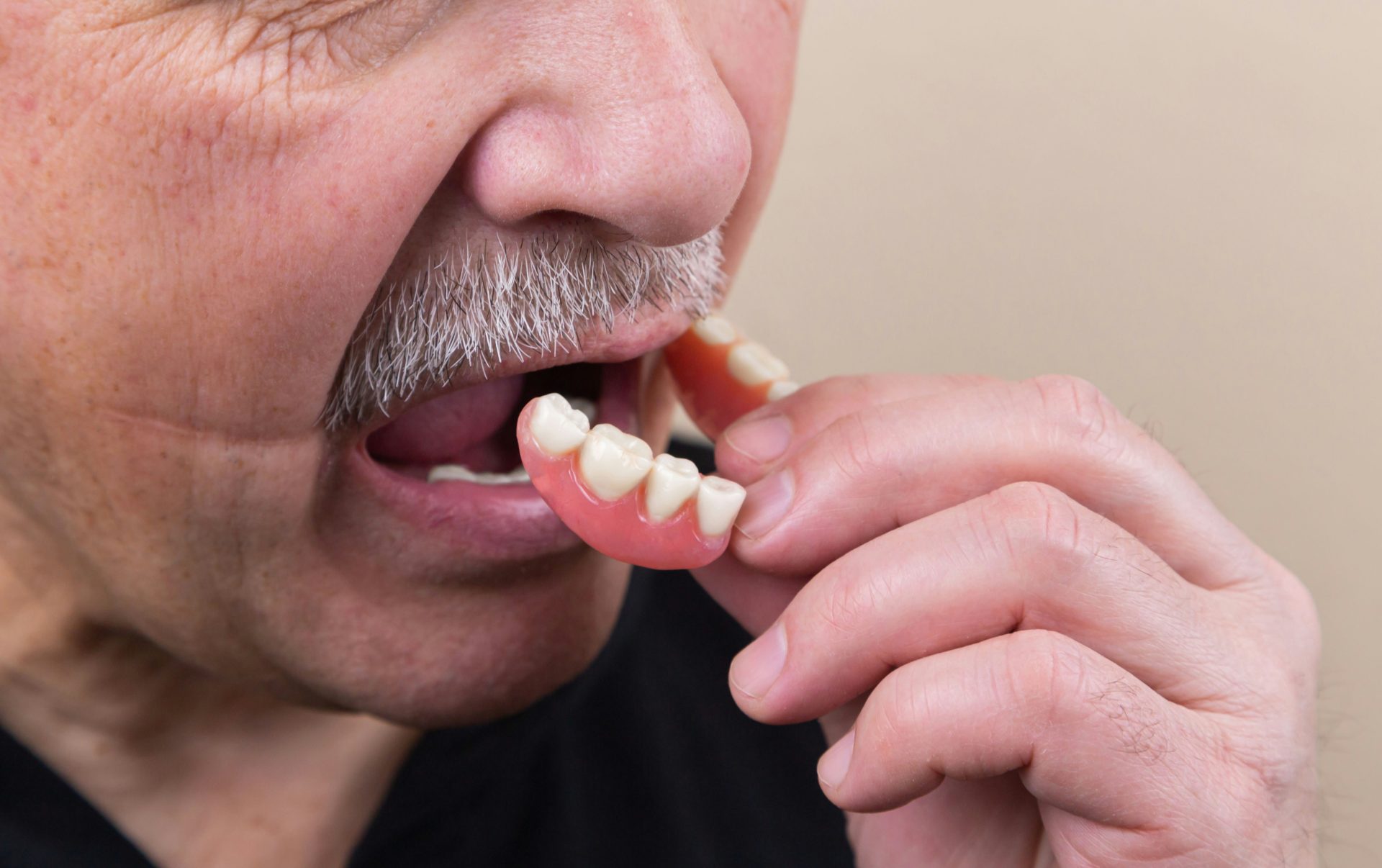 Man removing dentures from mouth